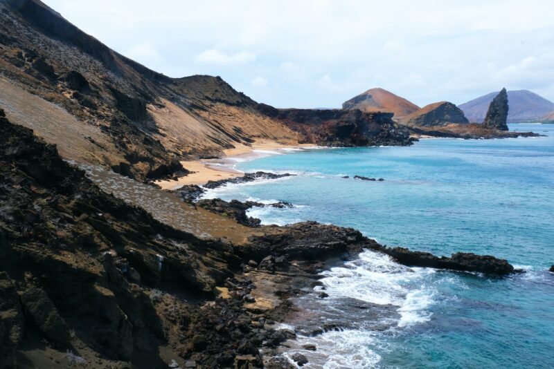 brown and green mountains beside body of water during daytime
